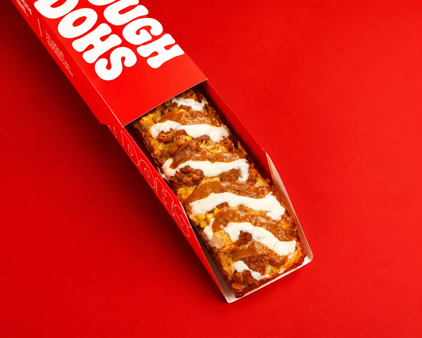 Dough Dohs Butter Chicken pizza with butter chicken sauce and ranch in its long branded red box on red